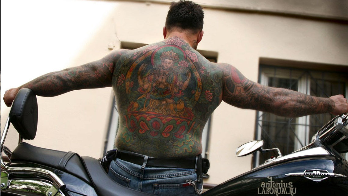 Татуированный мужчина на мотоцикле